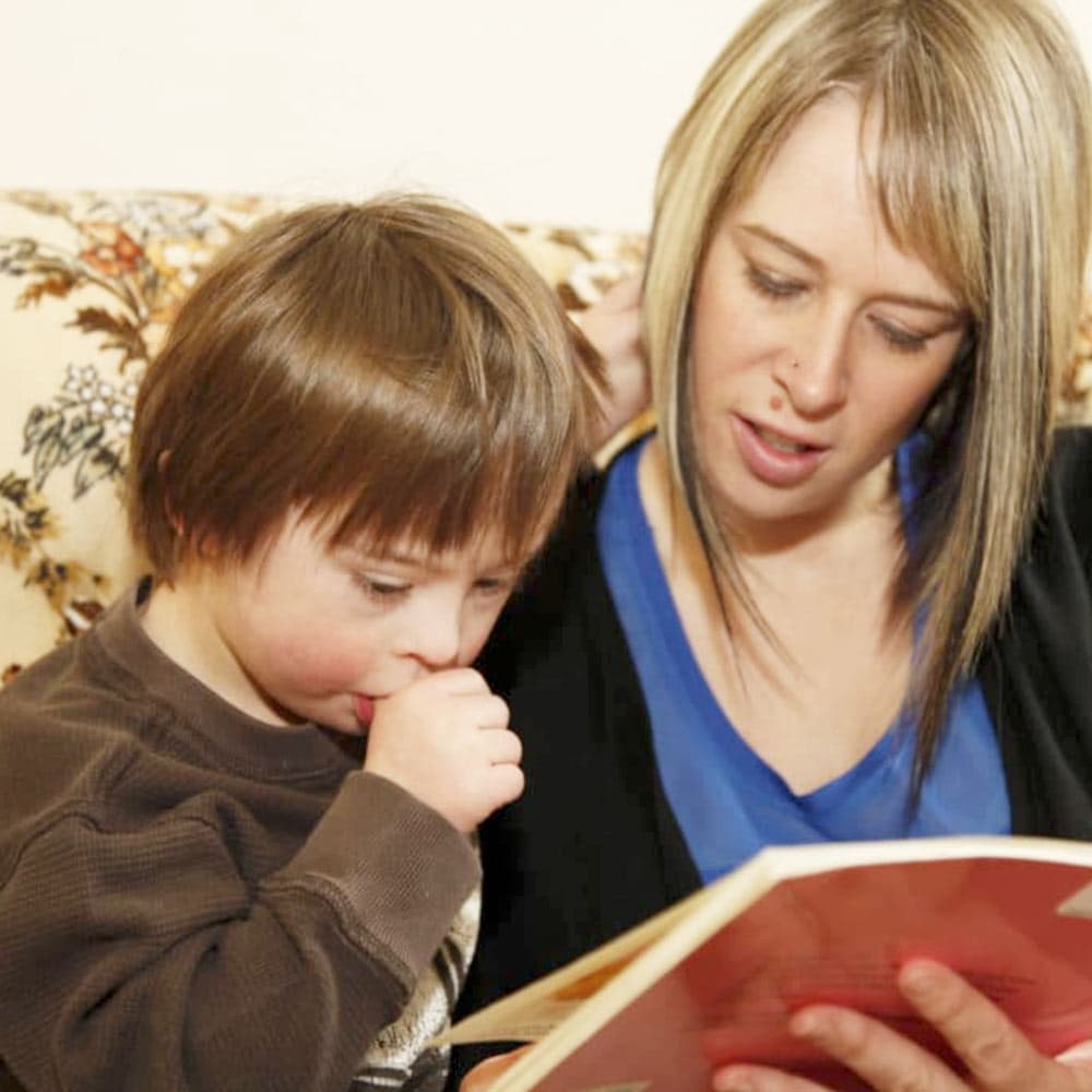 An ECE diploma student reading to a child